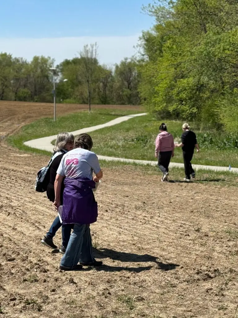 Members of the Ioway Community, including Tribal members and employees, take part in hand-spreading seed.