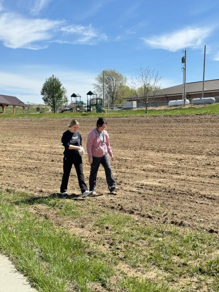 Members of the Ioway Community, including Tribal members and employees, take part in hand-spreading seed.