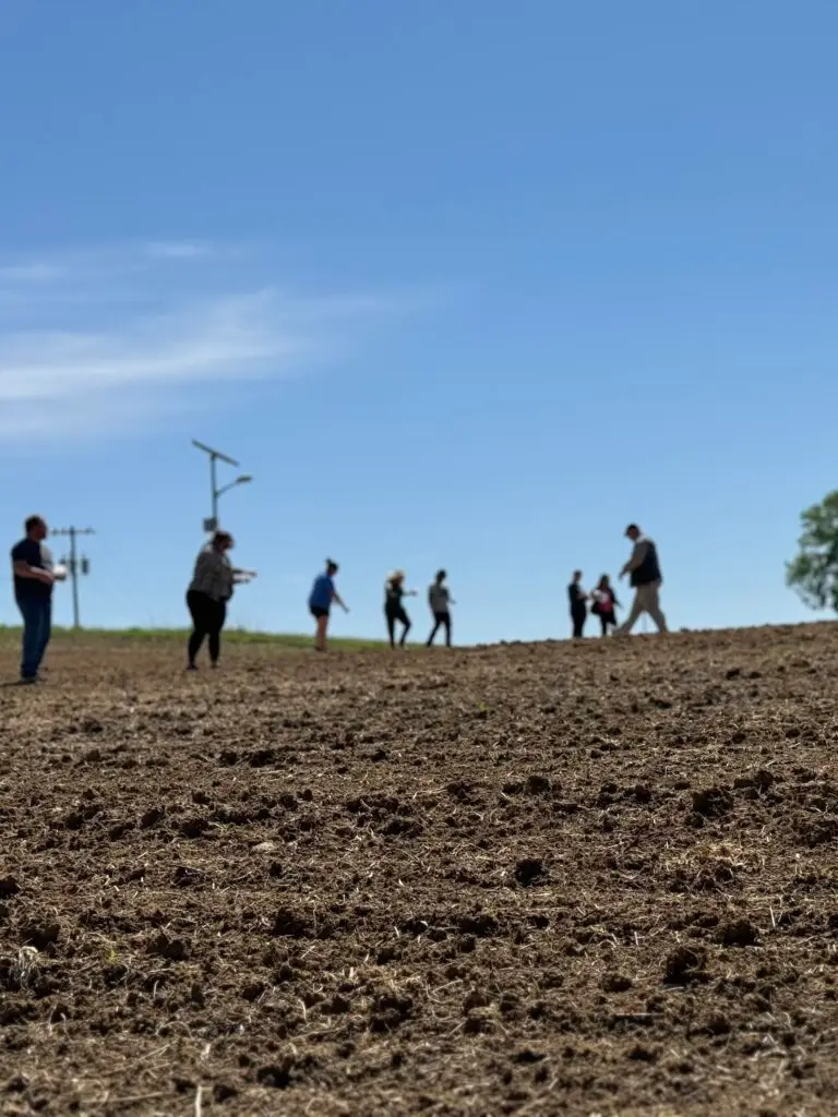 Members of the Ioway Community, including Tribal members and employees, take part in hand-spreading seed.