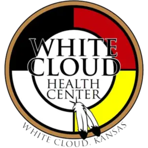 Logo of the White Cloud Health Center, featuring a medicine wheel in red, black, white, and yellow, with two feathers at the bottom and the text "White Cloud Health Center, White Cloud, Kansas."