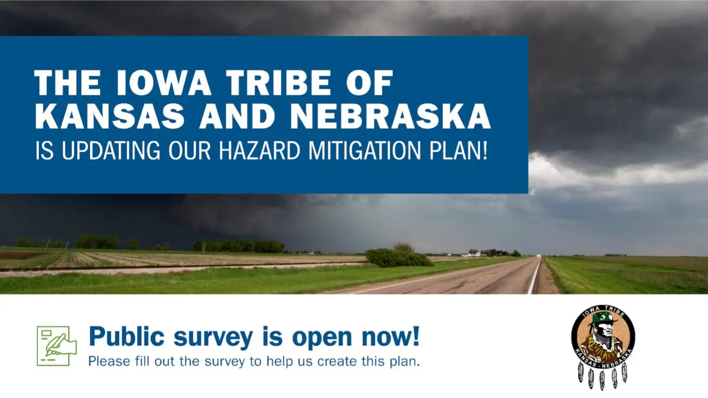 A stormy rural landscape with a dark, cloudy sky above a two-lane road and green fields. Overlaid on the image, a bold blue box reads, "The Iowa Tribe of Kansas and Nebraska is updating our Hazard Mitigation Plan!" Below the image, text on a white background reads, "Public survey is open now! Please fill out the survey to help us create this plan." The Iowa Tribe of Kansas and Nebraska logo appears in the lower right corner